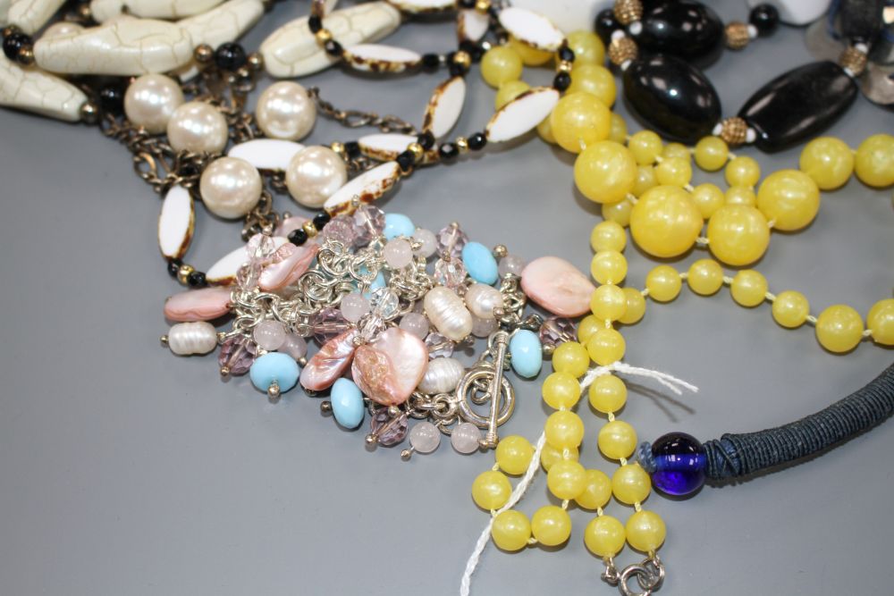Six assorted costume necklaces including simulated amber and a costume bracelet,